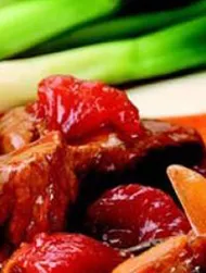 Rich beef casserole with tomatoes & shallots and bubble & squeak cakes